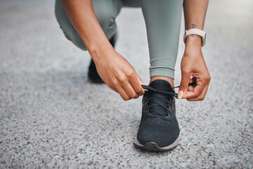 Obraz premium Fitness, woman and hands tying shoes outdoor to prepare for training, exercise and start workout for health on road. Sneakers, tie laces and runner ready for wellness, sports and closeup on street