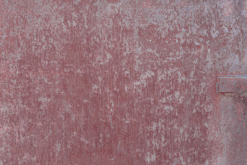 Fototapeta premium Fragment of a rusty grunge surface. Orange-brown background color. Scuffs and peeling of old paint. Scratches and traces of a welding seam.