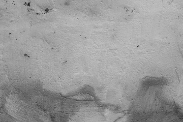 Monochrome texture of a concrete wall with natural relief and damage in the form of chips and scratches. Fragment of an old stone surface with a crack. Dark rough surface with a place for an inscripti