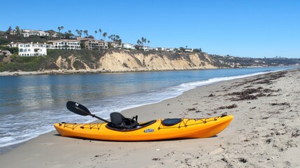 A vibrant yellow kayak and an oar sit on the pebbled beach as waves roll in, creating a serene atmosphere by the water's edge