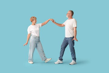 Naklejka premium Mature couple dancing on blue background