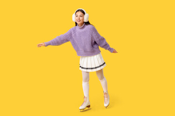 Naklejka premium Beautiful young Asian woman in ice skates on yellow background