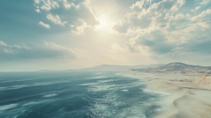 Obraz premium Serene Coastal Landscape with Blue Ocean, White Sandy Beach, and Rolling Hills Under a Sunny Sky.