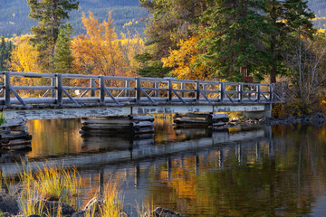 Fototapeta premium Wooden bridge across the lake to the little island in mountains.