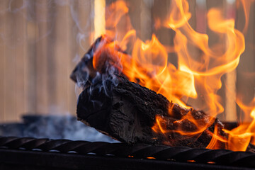 Close up of fire with orange red flames burning in darkness. Coal fire