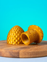 Close-up of a plastic egg model with ornament on a blue background