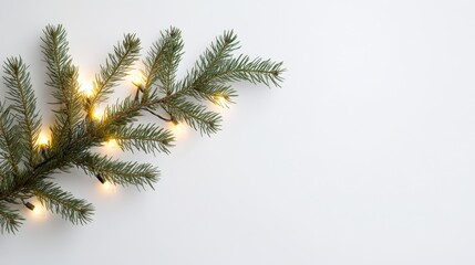 Obraz premium Minimalist Christmas Decor: Single Pine Branch with Tiny Lights on White Background