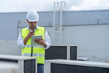 Asian maintenance engineer work on the roof of factory. contractor inspect compressor system and...