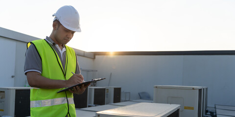 Asian maintenance engineer works on the roof of factory. contractor inspect compressor system and...
