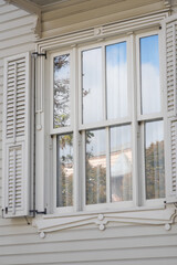 Obraz premium A Stunning Elegant White Window Featuring Shutters with a Beautiful Reflection Nearby