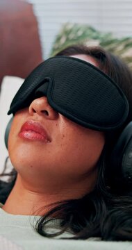 Woman, headphones and eye mask for psilocybin therapy on sofa with treatment of anxiety, depression and stress. Mental health, patient and counseling with natural medicine, micro-dosing and audio