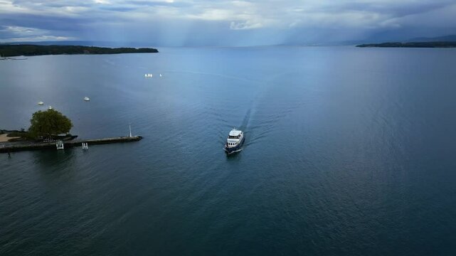 Orbit drone shot of boat arriving at Nyon Port on Lake Geneva in Switzerland