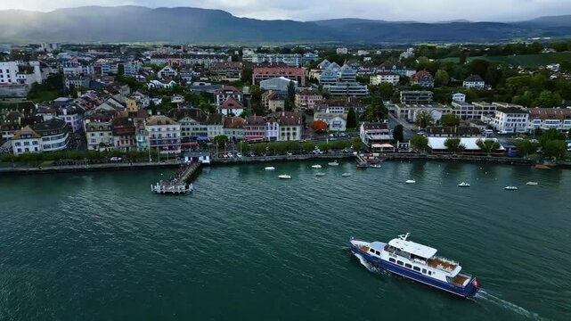 Parallax drone shot of boat arriving at Nyon Port on Lake Geneva in Switzerland