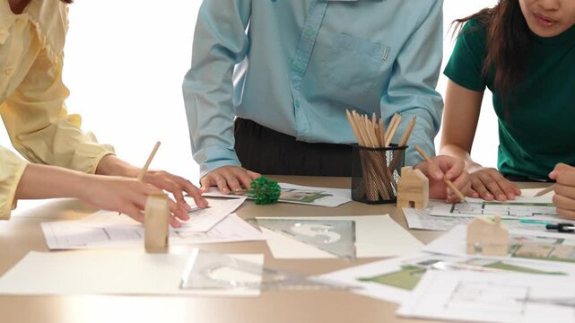 A video of architect use measurement tools and pencil to measure blueprint. Architect design house construction on a table at studio, with architectural plan scattered around. Focus hand. Delineation.
