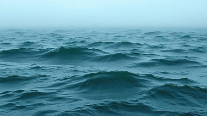 Fototapeta premium Ocean wave pattern in shades of green and blue under a misty sky, sea spray, serene environment, atmospheric conditions