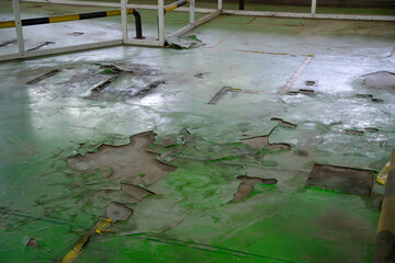 Green floor in an abandoned factory that is falling apart