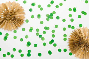 Christmas decoration flat lay, Christmas background. Paper golden garlands, green confetti, white background, copy space