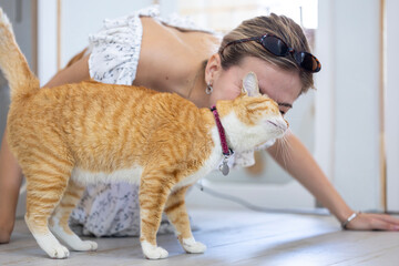 Cat owner is kissing and hugging her ginger cat with love and care after rescuing him from the pet shelter for sitter boarding service and life long companion partner concept