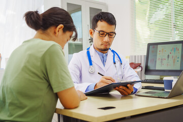 A male doctor sits at a desk in a hospital,reviewing a female patient’s medical history.He provides compassionate advice for depression, addressing symptoms like sadness,hopelessness, anger, anxiety