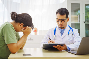 Fototapeta premium A male doctor sits at a desk in a hospital,reviewing a female patient’s medical history.He provides compassionate advice for depression, addressing symptoms like sadness,hopelessness, anger, anxiety