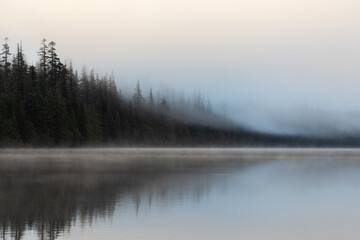 Obraz premium Beautiful misty fall weather, autumn vibes at Lost Lake in Oregon, near Hood River and Mount Hood, captured during early morning. Mystic fall vibes and scenery. 