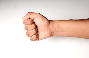 Close-up of closed hand, fist, rock gesture with white background. Hand of latin man.
