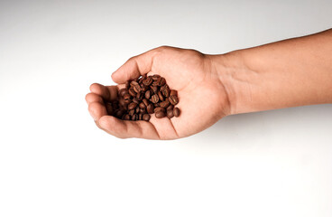 Hand of Latino man holding coffee beans on a soft background.
