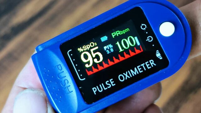 A man inserts his finger into a pulse oximeter to measure blood oxygen saturation and heart rate.