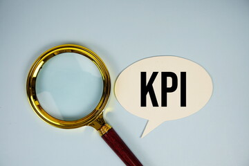 KPI text on speech bubble with magnifying glass top view on blue background