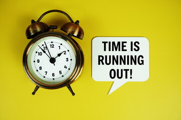 Time is Running out! text on speech bubble with alarm clock top view on yellow background