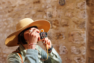 Beautiful woman takes pictures outdoors using an analog camera. travel to Arab countries.