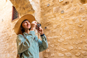 Beautiful woman takes pictures outdoors using an analog camera. travel to Arab countries.
