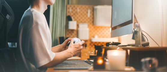 Relax asian man playing game console with controller at home office