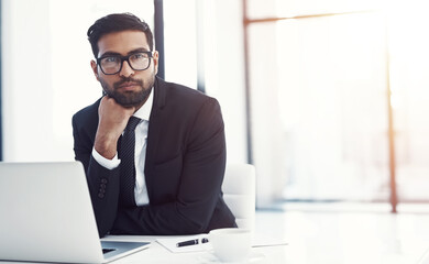 Laptop, portrait and serious with business man at desk in office for administration or research. Computer, glasses and internet with confident corporate employee in professional workplace for growth