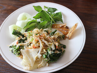 Urap-urap is a typical Indonesian dish consisting of boiled vegetables mixed with spiced grated coconut.