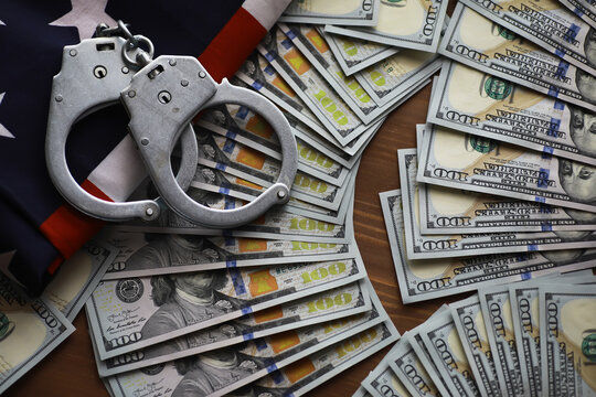 Handcuffs on US Dollar Bills Representing Financial Crime, Fraud, and Corruption