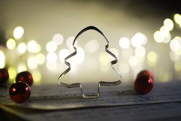 Christmas Tree Cookie Cutter with Festive Lighting and Sheet Music Background