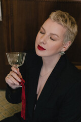 Elegant Woman Holding Glass with Red Ribbon, Glamorous Look, Close-Up Portrait