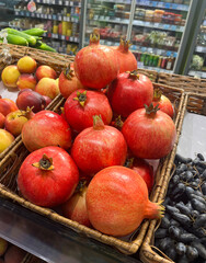Fresh pomegranates in the supermarket. Fruit shelf in a grocery store.
