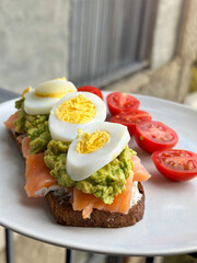 Sandwich with egg, avocado and red fish. A hearty homemade fish sandwich for breakfast.