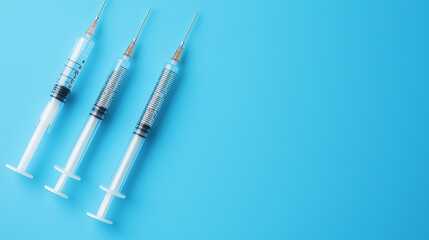 Naklejka premium Top view of medical syringes with needles on blue background with copy space