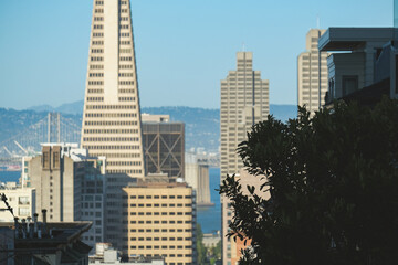 Picturesque Victorian house architecture with modern futuristic downtown San Francisco skyline silhouette panorama, cable car and bay view up and down hill
