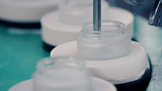 filling a pot of cosmetic cream in close-up on a production line