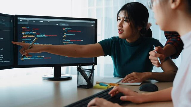 Slow motion back end software developer engineer for computer programming working together on debugging writing computing code, solving complex algorithms display on monitor in office. Burgeoning