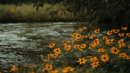 Yellow wildflowers bloom near a flowing river in a lush green meadow.