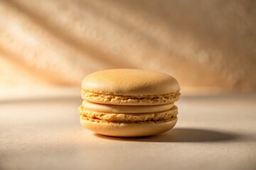 Close-Up Silhouette of a Beige Macaron on a Soft Beige Background, Perfect for Culinary and Dessert Photography, Highlighting Delicate Textures and Minimalist Aesthetic