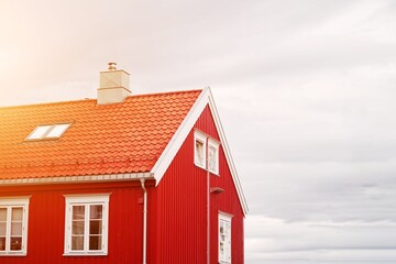 Small red wooden cabin house surrounded by nature in Norway