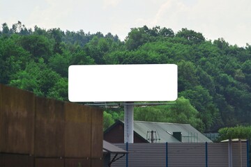 Blank advertising board on highway surrounded by nature