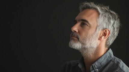 Obraz premium A thoughtful studio portrait of a man gazing off to the side, lost in contemplation