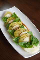 Yellow tomato caprese salad with mozzarella cheese